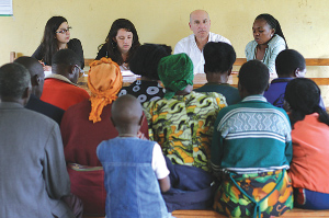 Fordham law professor James Kainen, center, and a team of Crowley program attendees speak with individuals with visual disabilities in northern Rwanda. Photo by David Harvey