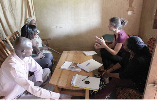 Crowley Fellow Aminta Ossom, right background, and Meghan Newcomer, third-year law student, right foreground, speak with community members outside Kigali, Rwanda. Photo by Matt Solomon