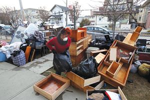 Home owner Kendra Newkirk, FCRH ’2000, bags personal items lost in Hurricane Sandy, which destroyed the contents of her home in the Rockaways. Photo by Bruce Gilbert