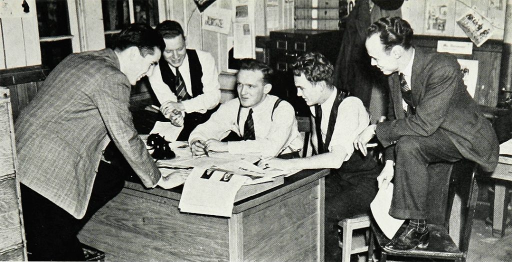 Editor-in-Chief Donovan (center) holds court with his fellow newsmen in the offices of The Ram.