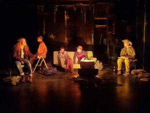 Actors in Mr. Burns sit around a metal canister in Pope Auditorium.