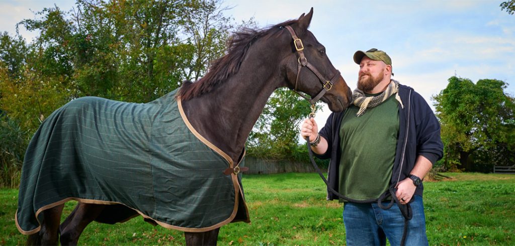 Matthew Ryba standing with a horse.