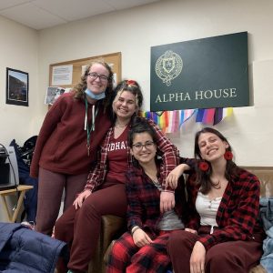 Four girls wearing maroon outfits smile at the camera.