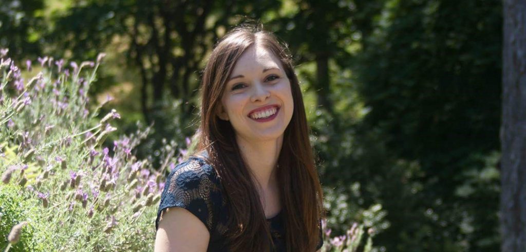 Woman smiling with flowers in background