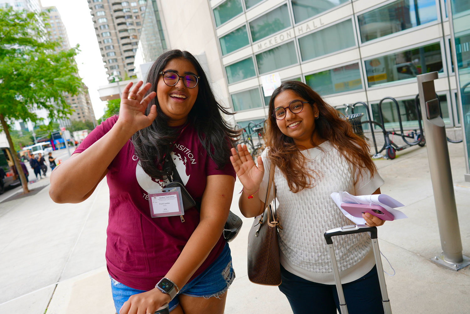 Preeti Lamba with a younger student smile and wave at the camera.
