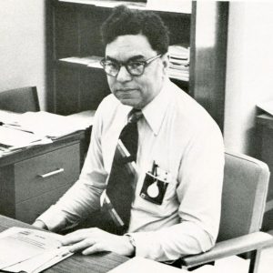 A black and white photo of Donald Clarke as a middle-aged man, sitting at a desk