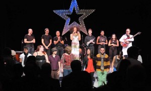 Jomama with band and choir in “Radiate,” at Theater Offensive, Boston in 2013. Photo Craig Bailey