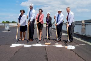 Lesley A. Massiah-Arthur, left, and representatives from the City of New York apply the first coat of white paint to the roof of O'Hare Hall.