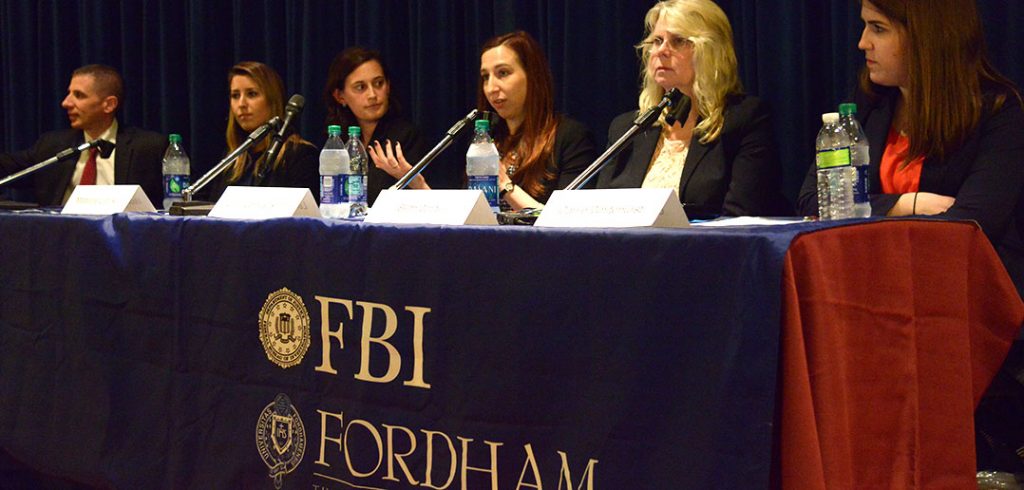 Women in Cybersecurity Panel sitting at long table with microphones