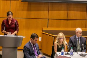 Erin Hoffman, associate director of Campus Ministry for Spiritual and Pastoral Ministries at Lincoln Center and director of Ignatian Initiatives, stands at a podium with her head down, at the McNally Ampitheatre