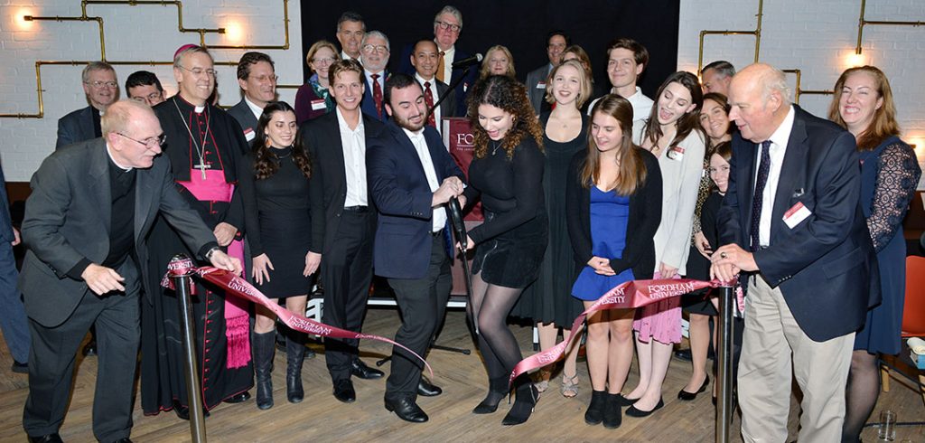 Students, faculty, and adminstrators laugh and smile at ribbon cutting for London Centre