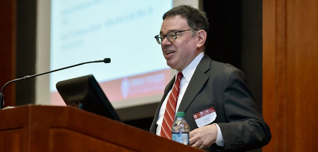 Fordham professor Mark Conrad speaking at podium during a November 2018 lecture