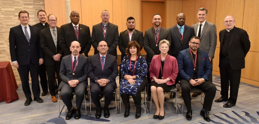 The awardees, seated/standing in two rows, pose for a formal picture.