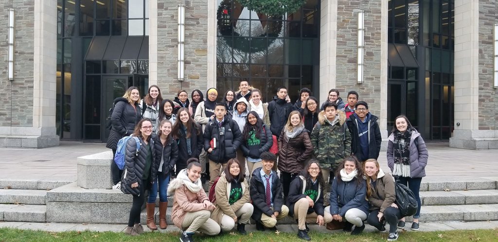 Fordham undergraduate students and students from Mott Hall High School pose for a group photo on the steps of Walsh Library.