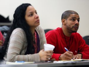 Two guests take notes during the conference.