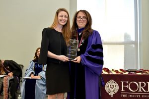 Caroline Dahlgren, wearing a black dress, holds an award with Donna Rapiaccioli, wearing purple