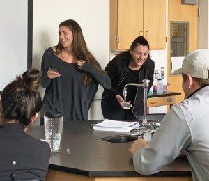 Two woman giggling in the lab room. 