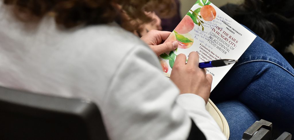 member in audience takes notes