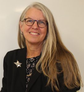 A woman with long blonde hair and glasses