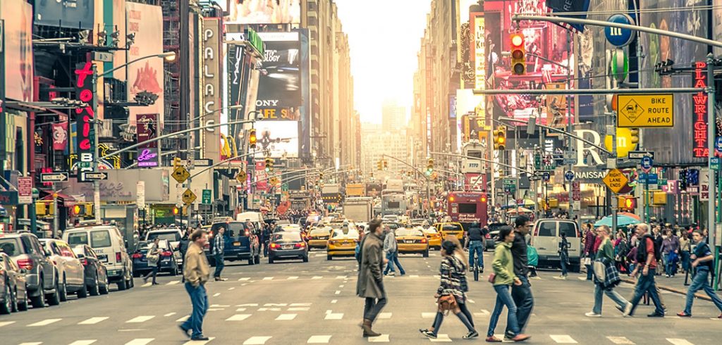 People walk across a street in New York City