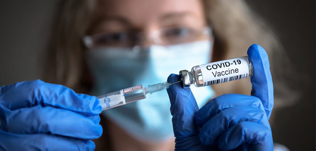 A doctor preparing to inject the COVID-19 vaccine