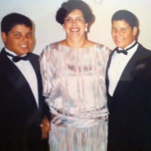 A woman stands between 12-year-old twin boys.