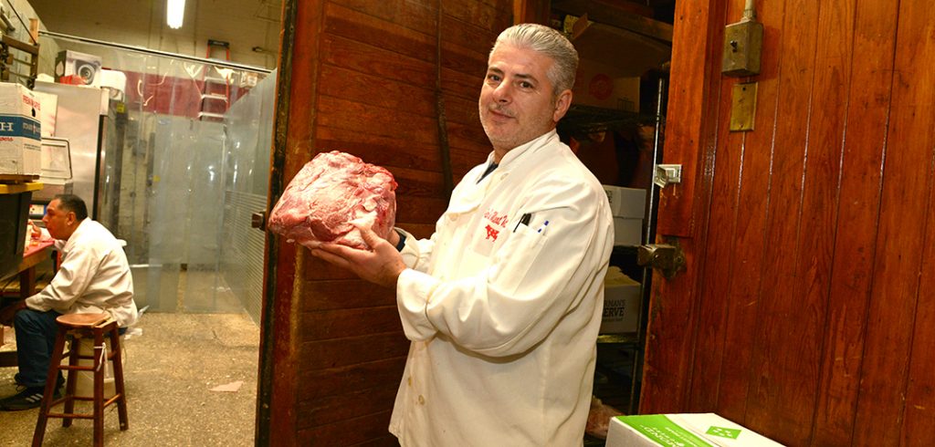 Jimmy at Peter's Meat Market pulls a fresh port butt from the walk-in fridge.