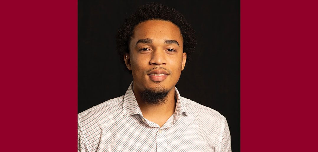 A portrait of Fordham graduate Diontay Santiago from the chest up against a black background