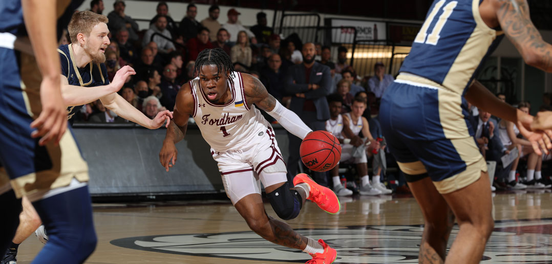 A basketball player dribbles to the hoop