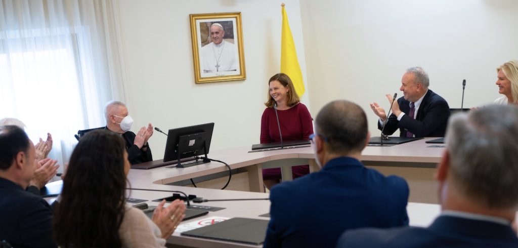 A group of people smile in a conference room.