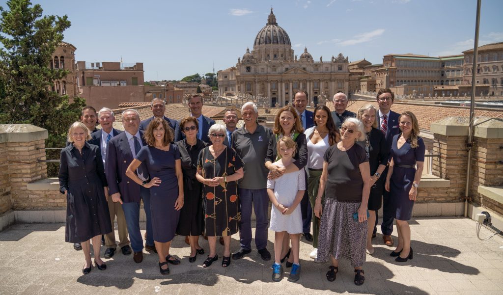 An outdoor group photo in front of a large white church dome