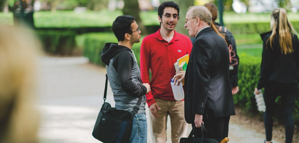 Three men talk at Fordham