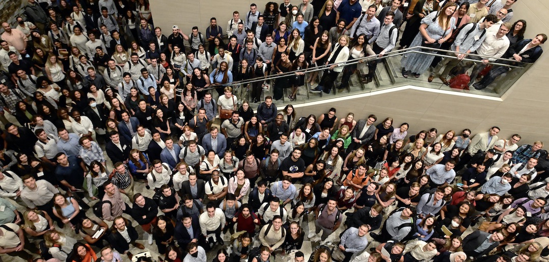 An aerial view of hundreds of students looking up and smiling