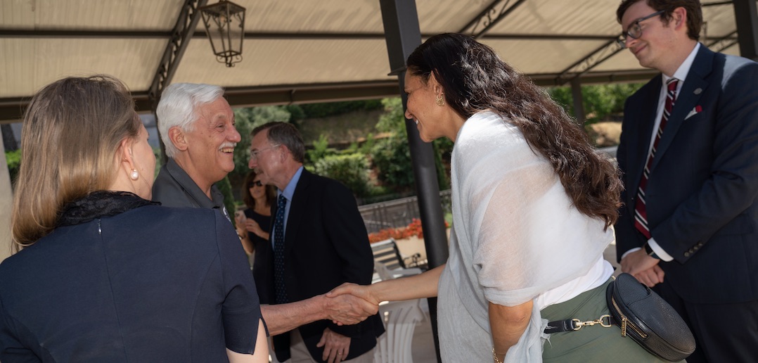 A woman shakes the hand of a smiling man.