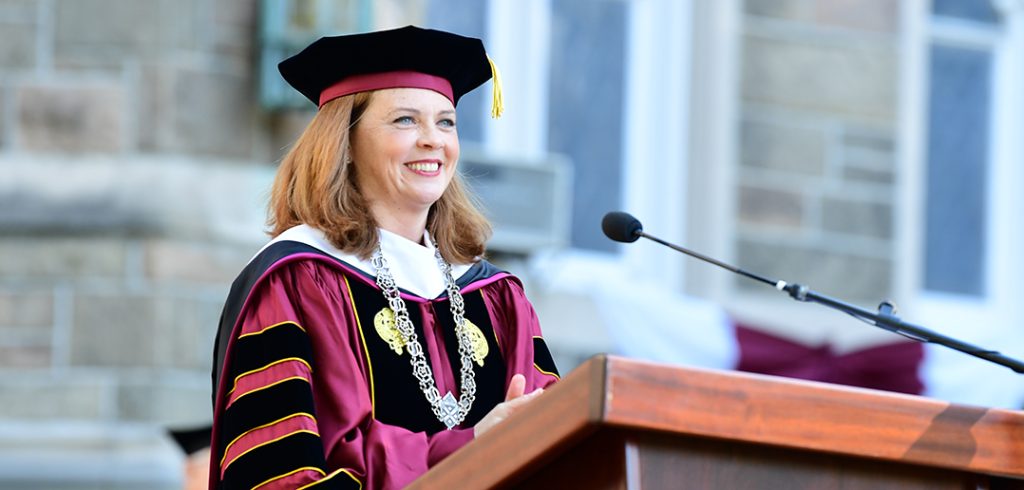 President Tetlow at podium in academic robes