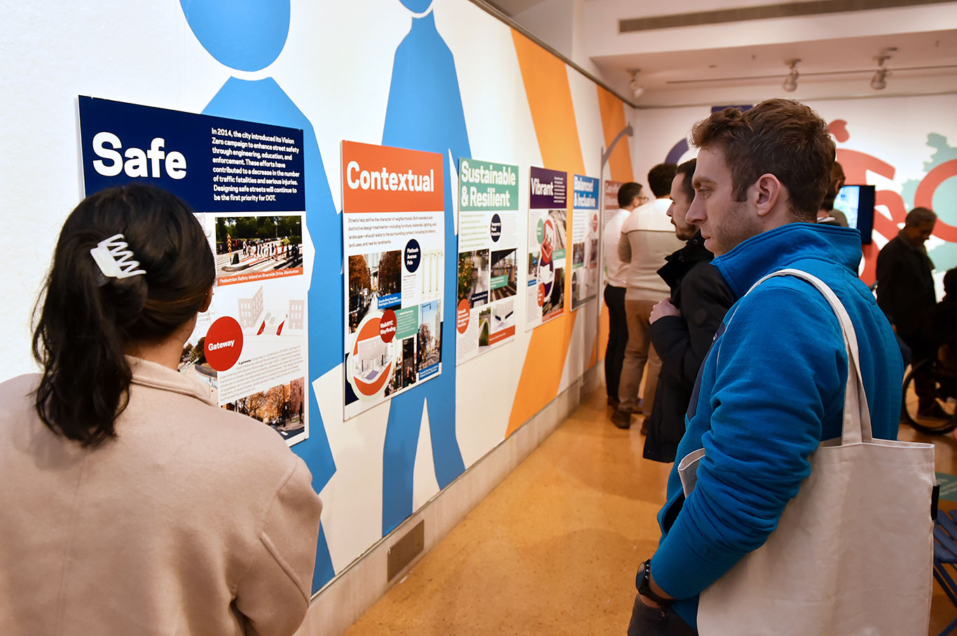 A woman and a man look at panels on the wall