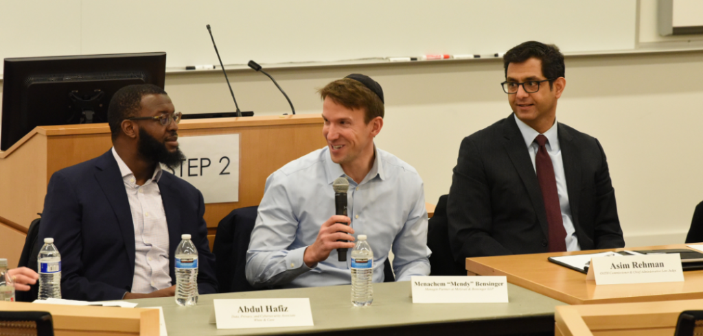 Three men sitting at panel