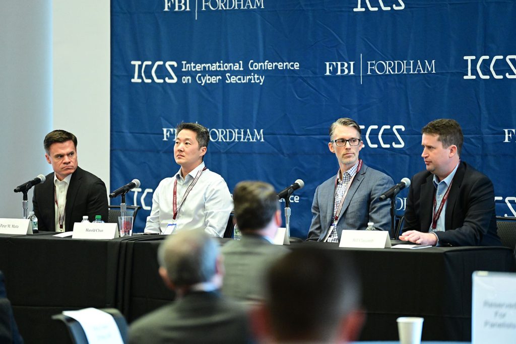 Moderator Peter M. Marta, Harold Chun, Darron Smith, Bill Claycomb, sitting together in front of microphones