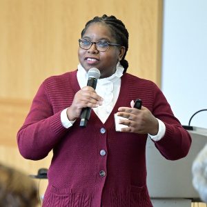 Marie Thomas speaks while holding a microphone.