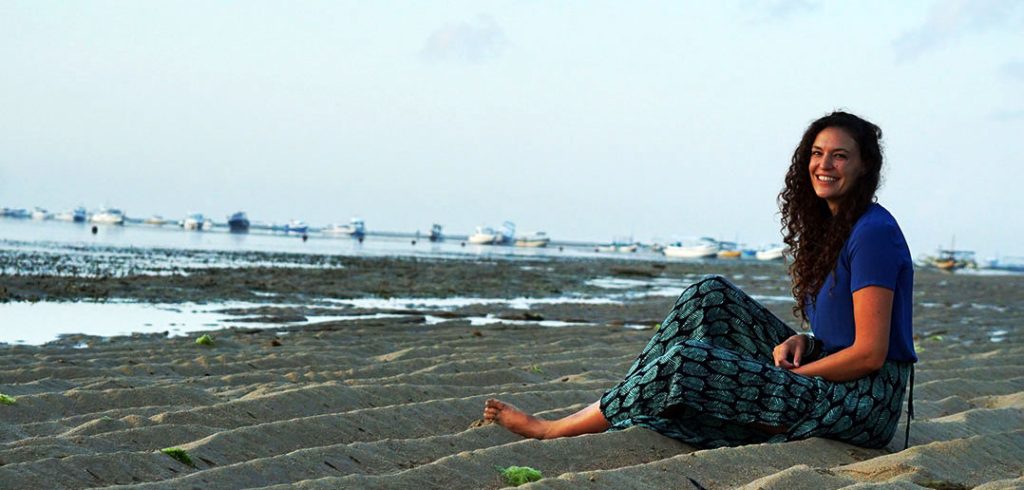 Giselle Schmitz sitting on Sanur Beach in Bali, Indonesia