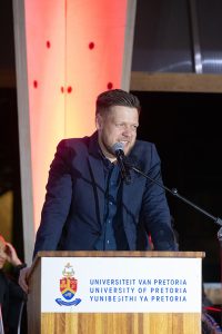 A man in a suit standing at a podium.