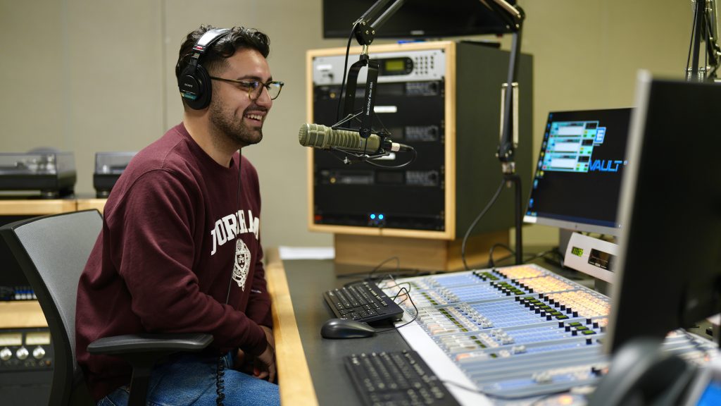 David Escobar speaks into a mic at a WFUV recording booth. 