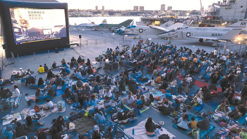 Group of people watching a movie on blankets, on the Intrepid Museums Flight Deck