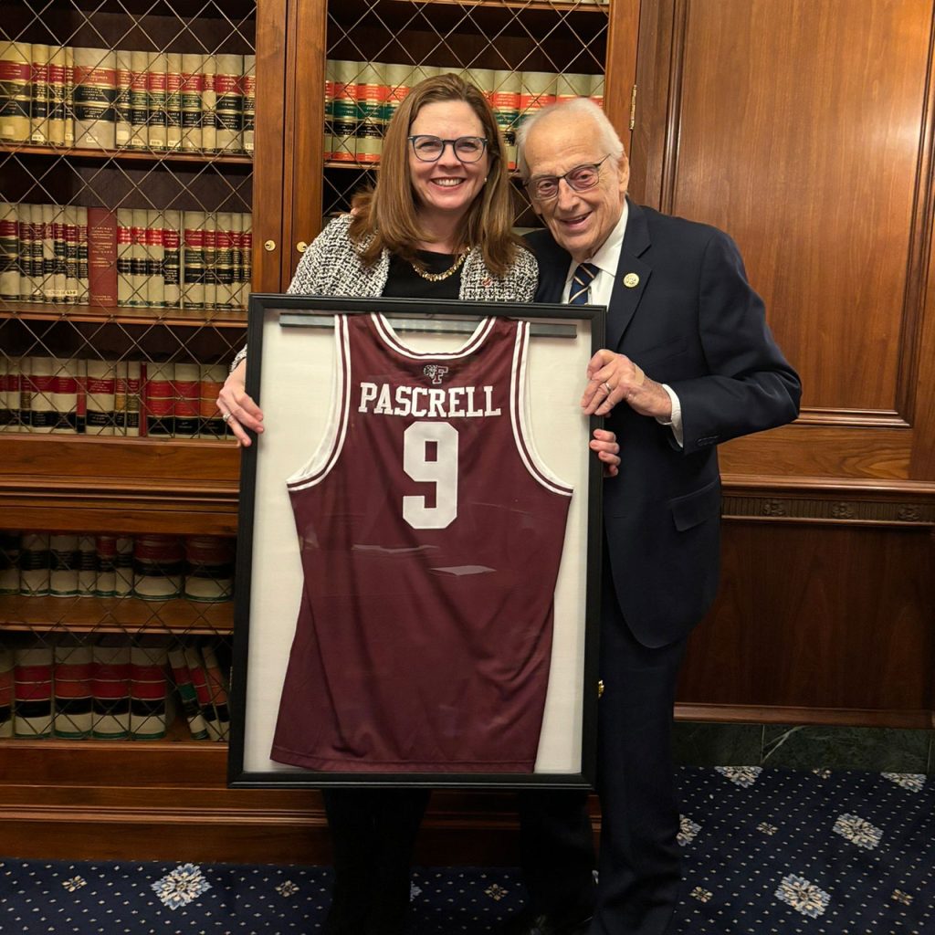 Fordham President Tania Tetlow gifts Bill Pascrell a Fordham basketball uniform with the the number 9, a reference to his congressional district. Photo courtesy if Bill Colona.