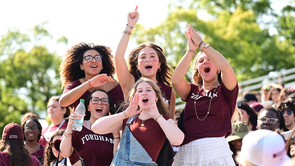 Students celebrate a Fordham touchdown in the stands at Moglia Stadium.