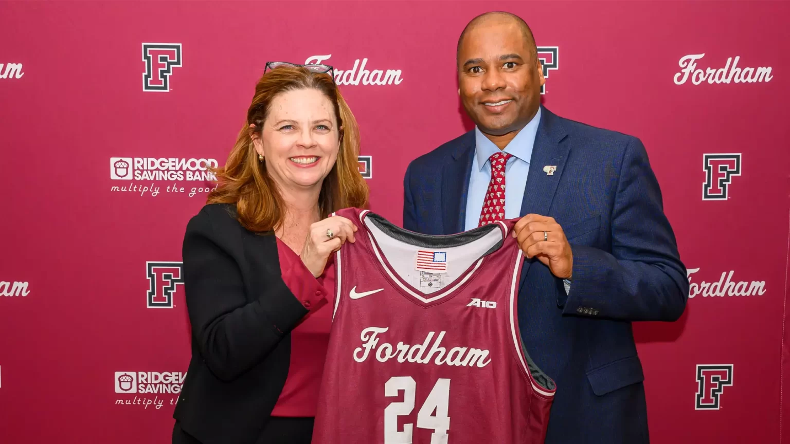 President Tetlow (left) and Charles Guthrie (right) holding Fordham 24 basketball jersey