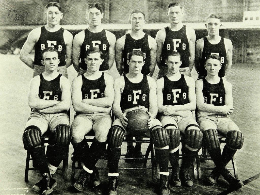 The 1925 Fordham men's basketball team poses for a group photo in their uniforms in the Rose Hill Gym