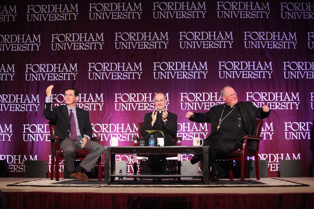 From left: Stephen Colbert, James Martin, S.J., and Cardinal Timothy Dolan on stage in the Rose Hill Gym