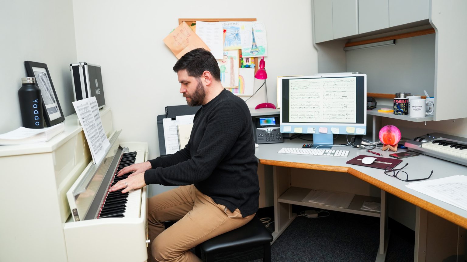 Dan Ott plays a piano in his office.