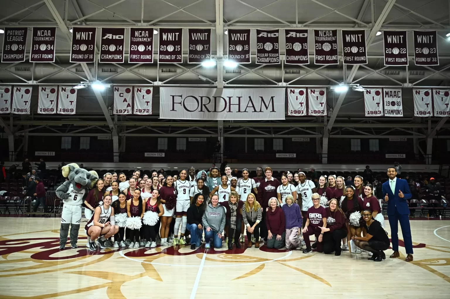 Group photo of women's basketball team with coaches and Ramses.